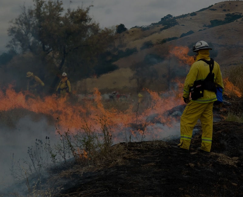 Firefighter facing fire outdoors