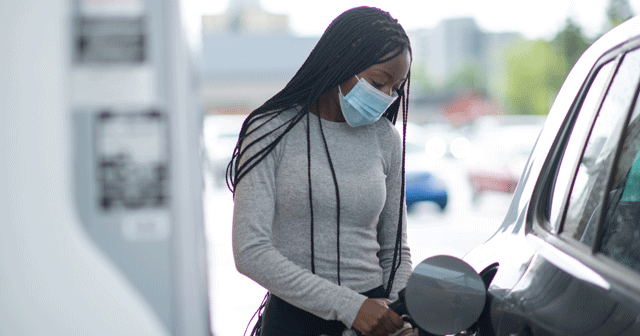 Blog Header Woman wearing mask while pumping gas