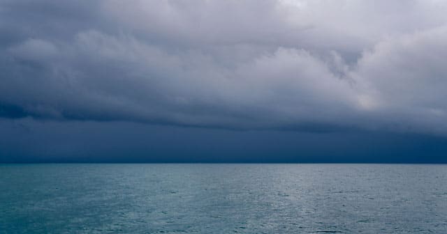 dark blue threatening skies over calm ocean